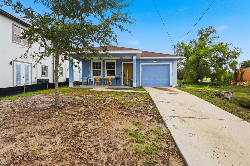 A blue single-story house with a front porch, attached garage, and a concrete driveway — 2215 E COLUMBUS DRIVE, TAMPA, FL