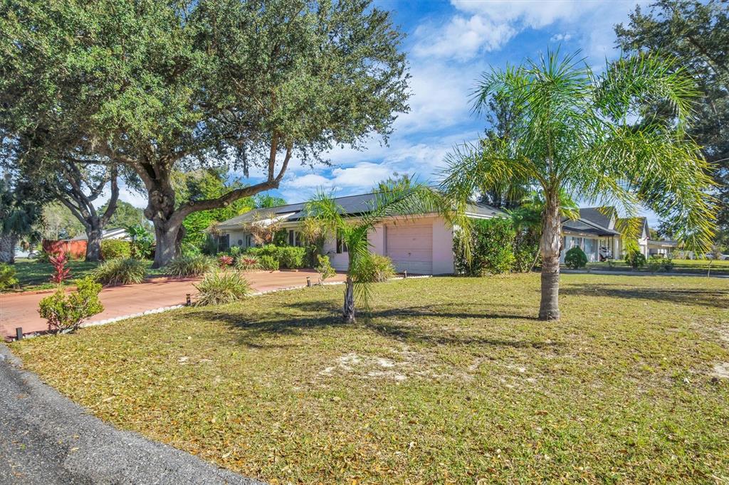A single-story house with a garage and a large tree in the front yard — 105 OWEN CIRCLE S, AUBURNDALE, FL