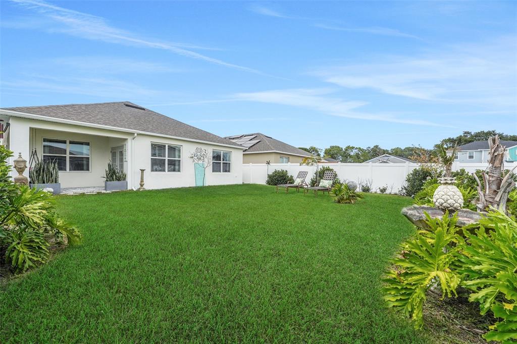A backyard with a green lawn, a white house, and a white privacy fence — 1109 BRIMSTONE CIRCLE, WINTER HAVEN, FL