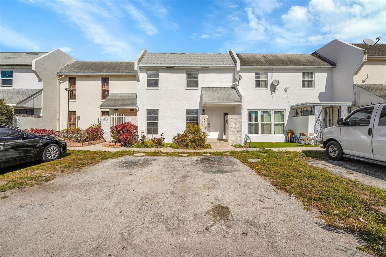 A row of white townhouses features a shared gravel parking area in the front — 1237 Seaview # 1237, North Lauderdale FL 33068, NORTH LAUDERDALE, FL