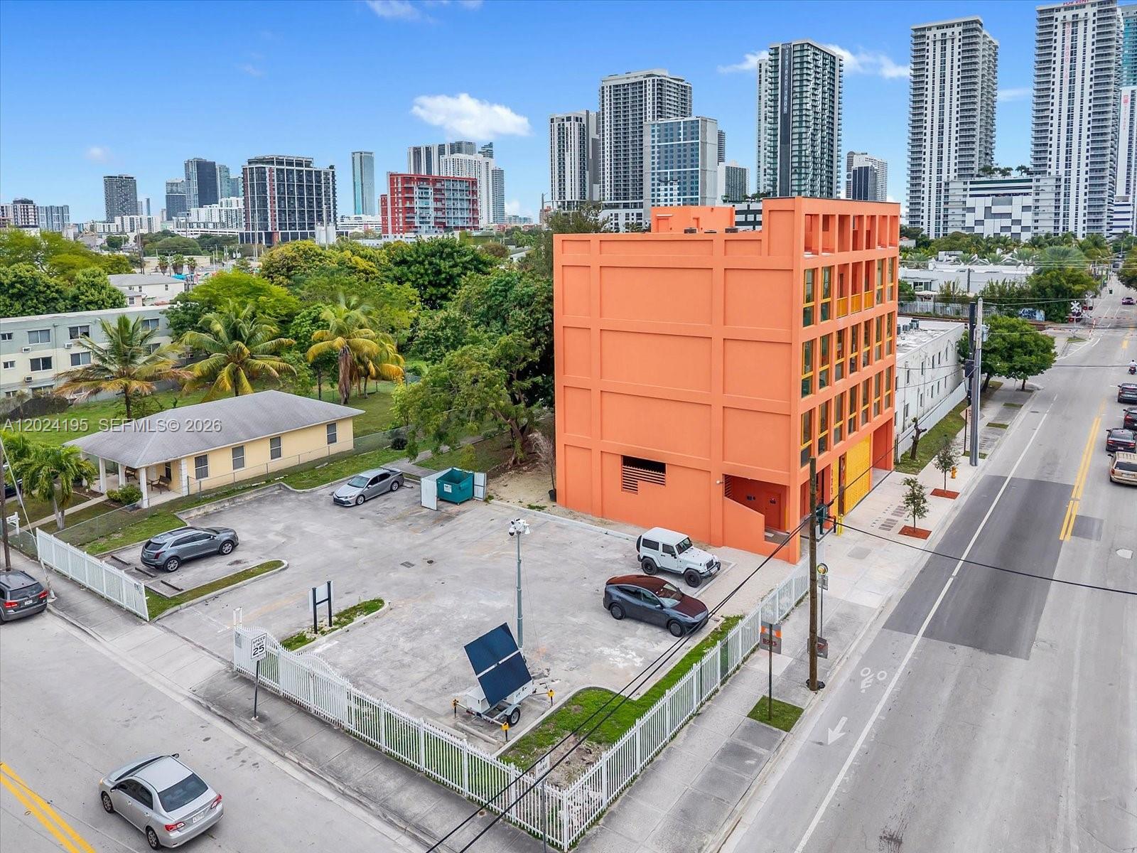 An aerial view shows a bright orange building next to a parking lot and street — 123 NW 14th St # 201, Miami FL 33136, MIAMI, FL