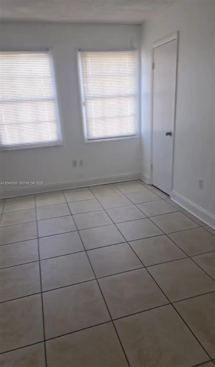 This room features white walls, two windows with blinds, and light-colored square floor tiles — 2777 L B MCLEOD RD # C, Orlando FL 32805, ORLANDO, FL