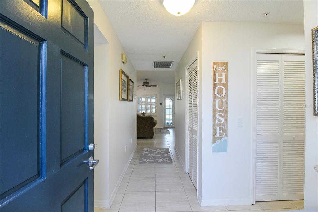 A tiled entryway leads into a hallway with a beach-themed sign and louvered closet doors — 1291 SIESTA BAYSIDE DRIVE UNIT 1291A, SARASOTA, FL