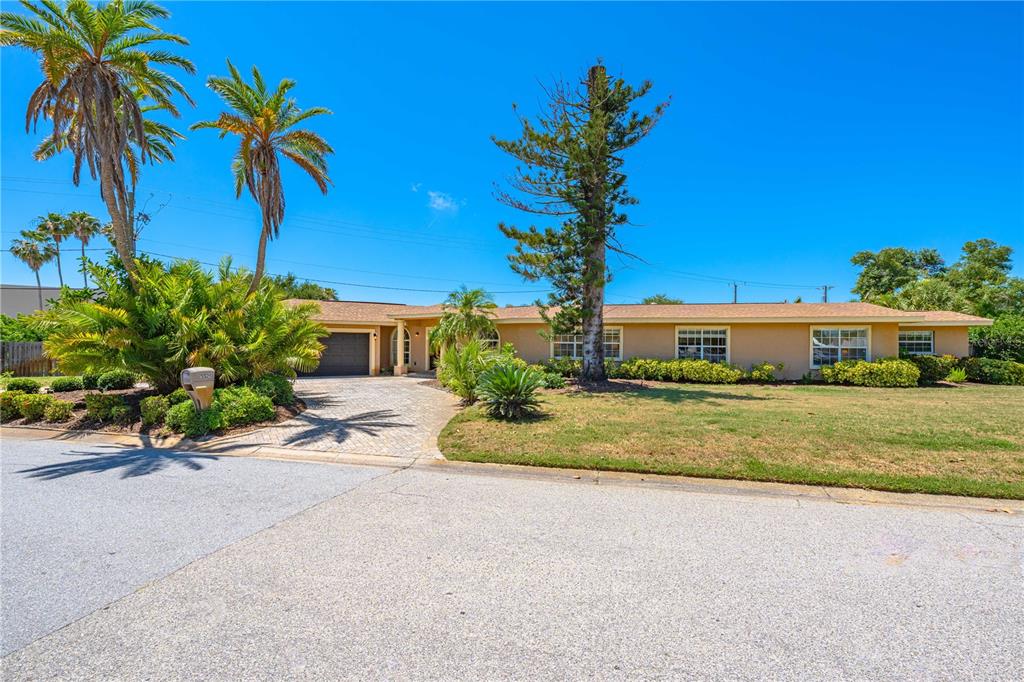 A single-story house with a tan exterior, a paved driveway, and several palm trees — 3524 S SCHOOL AVENUE, SARASOTA, FL