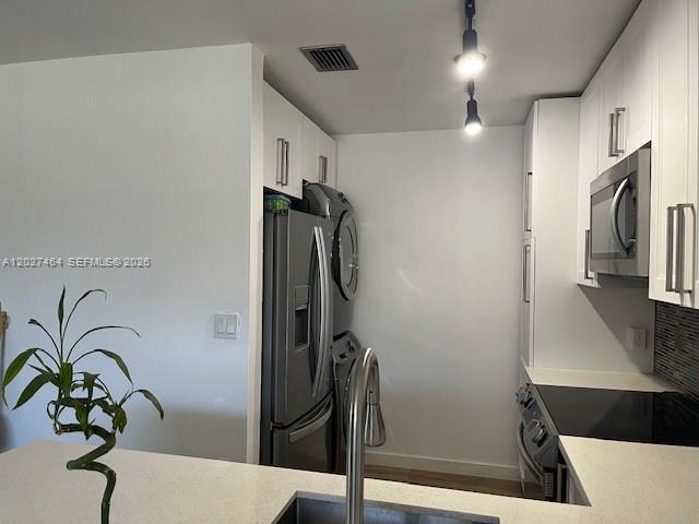 A modern kitchen features white cabinetry, stainless steel appliances, and a light-colored countertop — 10054 Winding Lake Rd # 201, Sunrise FL 33351, SUNRISE, FL