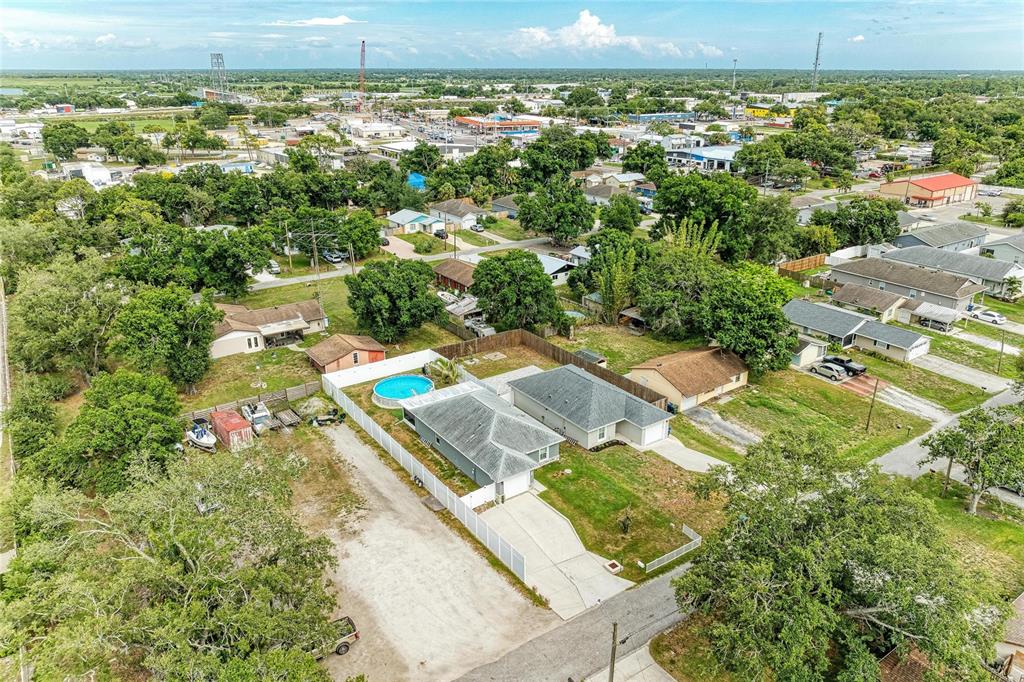 An aerial view shows a residential property with a house, pool, and large gravel driveway — 823 BACON AVENUE, SARASOTA, FL
