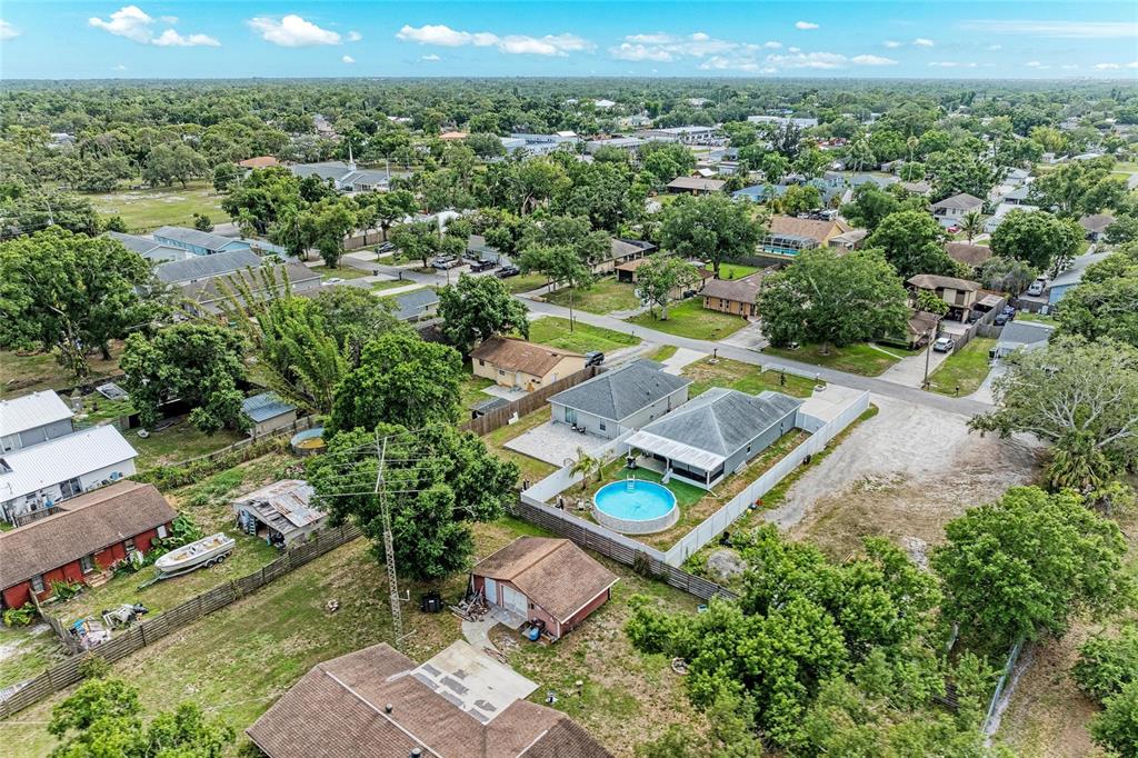 An aerial view shows a residential neighborhood with houses, yards, and an above-ground pool — 823 BACON AVENUE, SARASOTA, FL