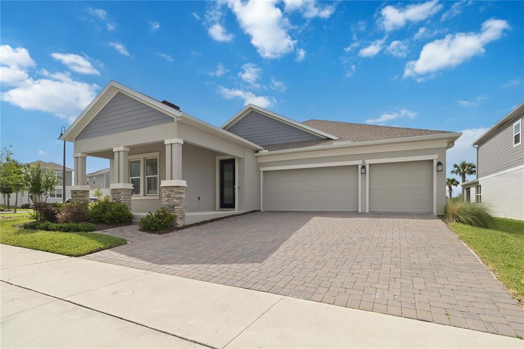 A single-story house with a paved driveway, two-car garage, and a covered front porch — 3000 ELLA WAY, ST CLOUD, FL