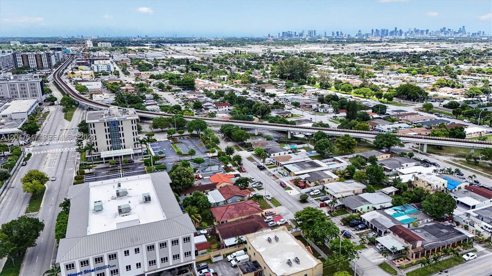 An aerial view shows a suburban neighborhood with a medical center, elevated train tracks, and buildings — 525 E 24th St, Hialeah FL 33013, HIALEAH, FL
