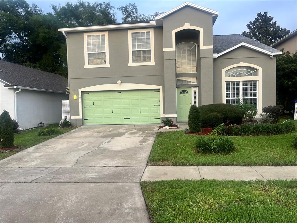 A two-story gray house features a light green garage door and front door — 4015 LAKESIDE RESERVE LANE, ORLANDO, FL