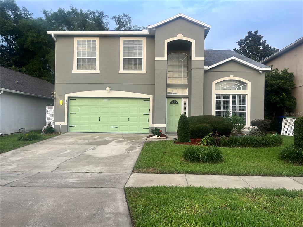 A two-story gray house features a light green garage door and matching front door — 4015 LAKESIDE RESERVE LANE, ORLANDO, FL