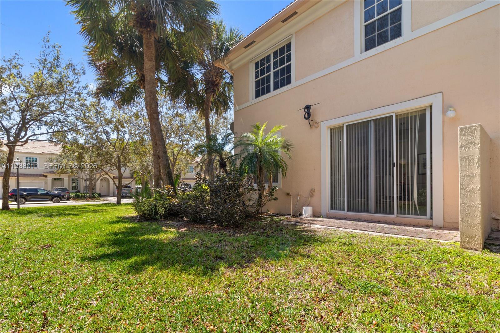 A two-story stucco house exterior features a sliding glass door and a small backyard — 2883 SW 85th Ave # 106, Miramar FL 33025, MIRAMAR, FL