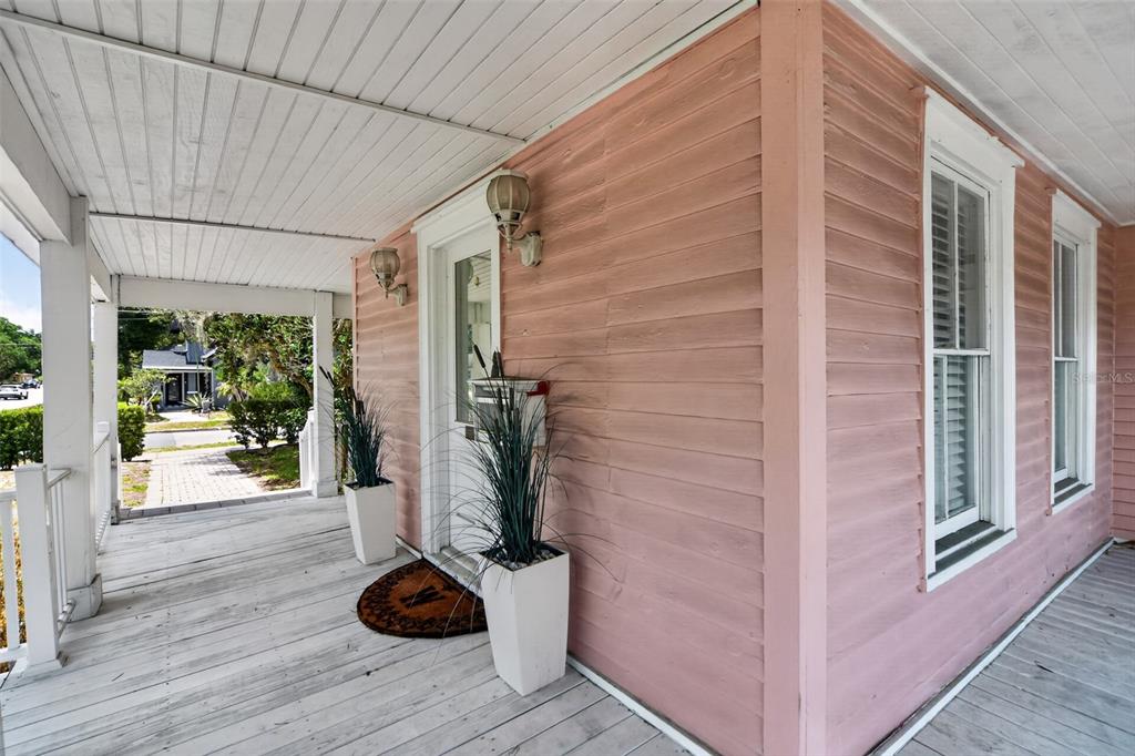 A pink-sided house features a covered wooden porch with two potted plants by the door — 19 W PRINCETON STREET, ORLANDO, FL