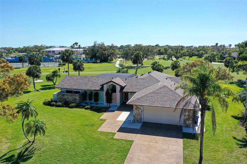 An aerial view of a single-story house with a stone facade and a golf course — 3704 PRAIRIE DUNES DRIVE, SARASOTA, FL