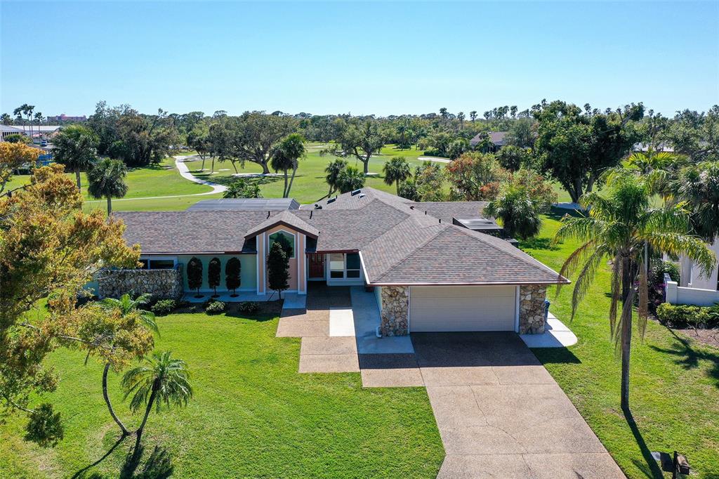 An aerial view of a single-story house with a stone facade and a golf course — 3704 PRAIRIE DUNES DRIVE, SARASOTA, FL