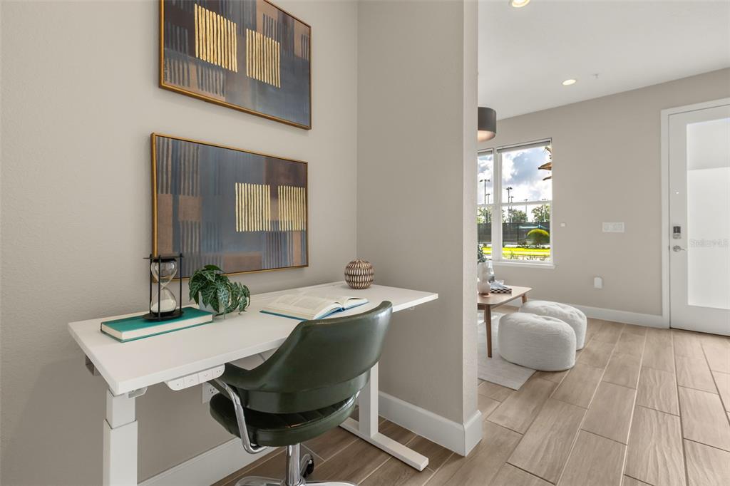 A modern living area features a white chair, wooden coffee table, and a staircase — 2058 PACKING DISTRICT WAY, ORLANDO, FL