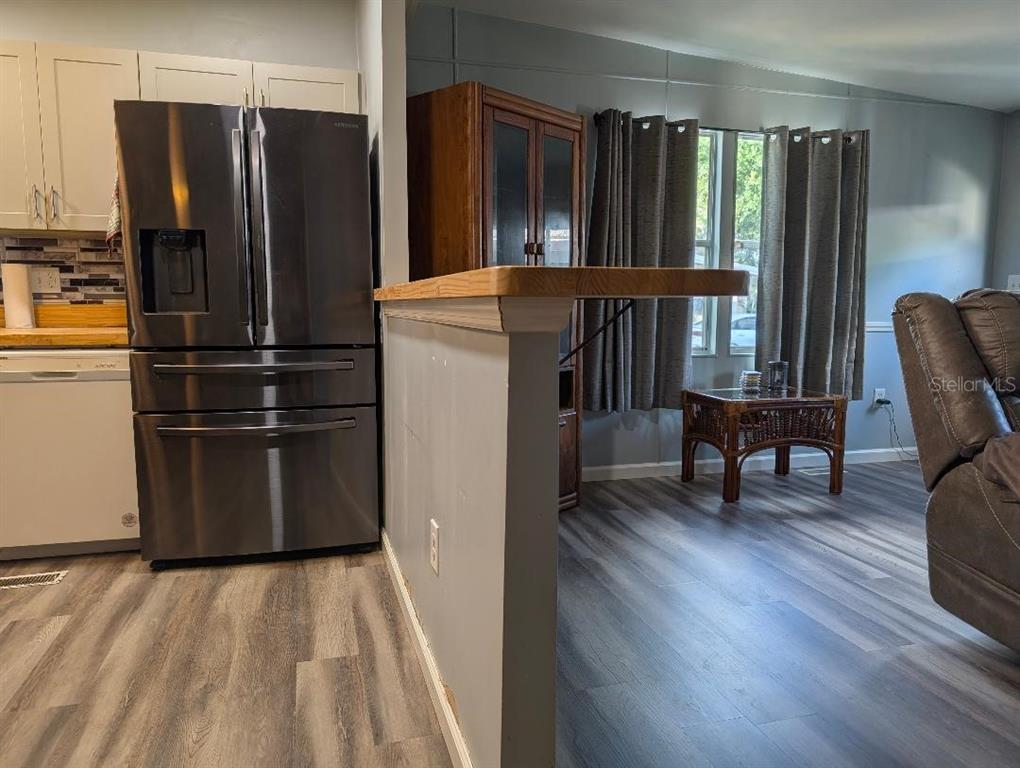 A kitchen with stainless steel appliances and a breakfast bar overlooking a living area — 7111 142ND AVENUE N Lot 101, LARGO, FL