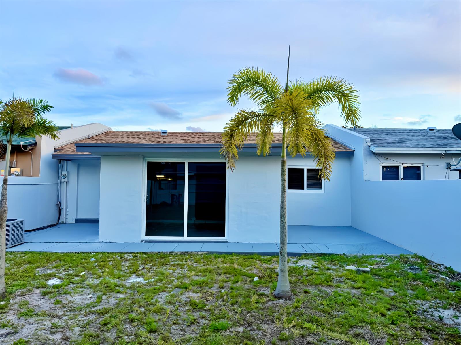 A light blue house exterior features a sliding glass door, a window, and two palm trees — 2941 NW 195th Street, Miami Gardens FL 33056, MIAMI GARDENS, FL