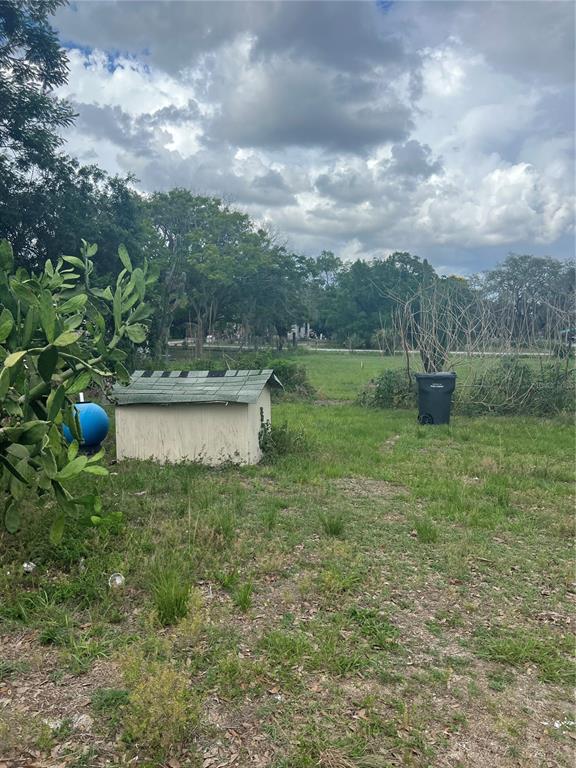 A grassy backyard features a small shed, a blue water tank, and a trash bin — SHADY OAK AVENUE, LAKE WALES, FL