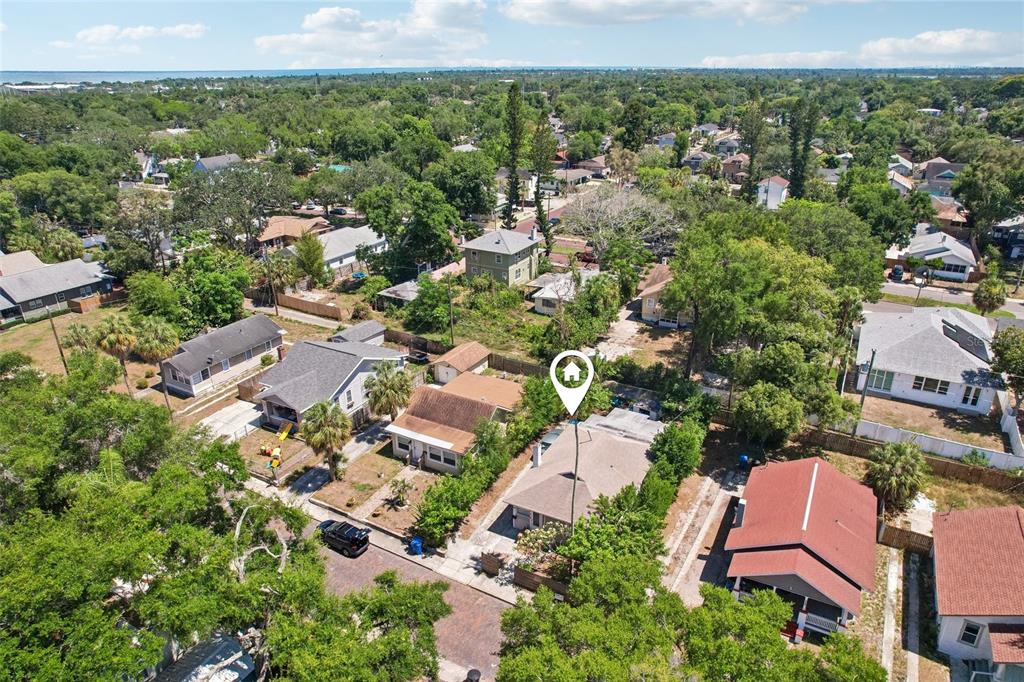 An aerial view shows a residential neighborhood with several houses and mature trees — 1028 8TH AVENUE S, ST PETERSBURG, FL