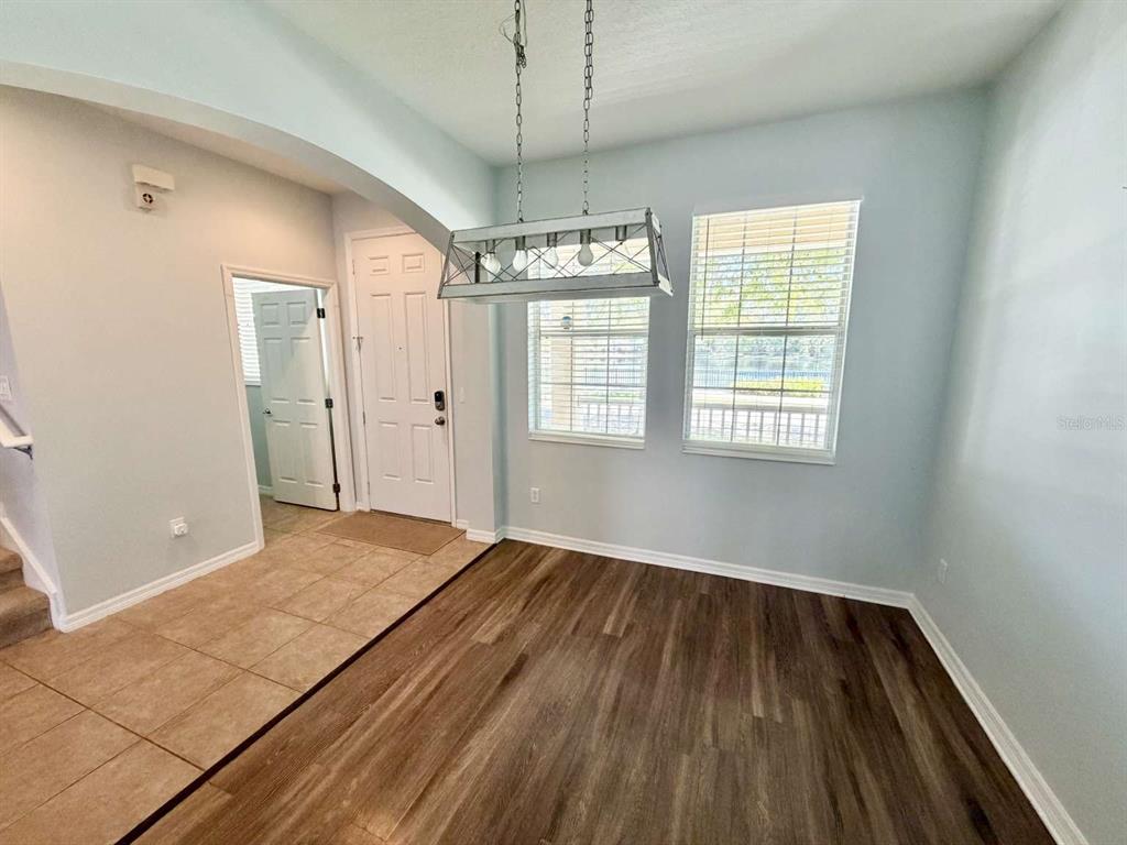 A dining area features wood-look flooring, a light fixture, and two windows with blinds — 9244 CARDINAL MEADOW TRAIL, ORLANDO, FL