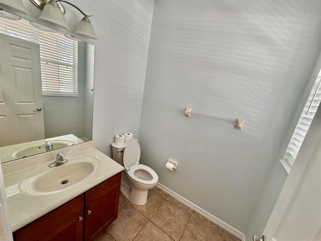 A bathroom features a vanity with a sink, a toilet, and a wall-mounted towel bar — 9244 CARDINAL MEADOW TRAIL, ORLANDO, FL