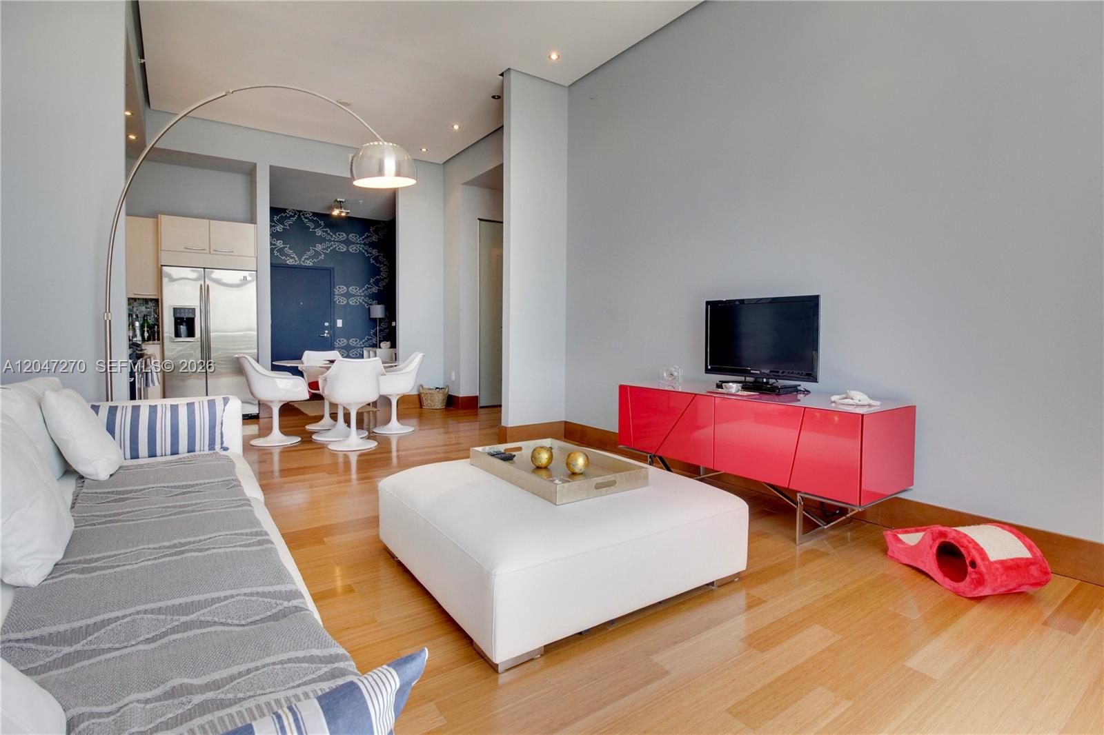 A living room features a white ottoman, a red media console, and a dining area — 2001 Meridian Ave # 21, Miami Beach FL 33139, MIAMI BEACH, FL