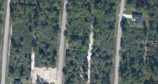 An aerial view shows a vacant, wooded rectangular lot outlined in green between two roads — 5044 PUEBLO AVENUE, SEBRING, FL