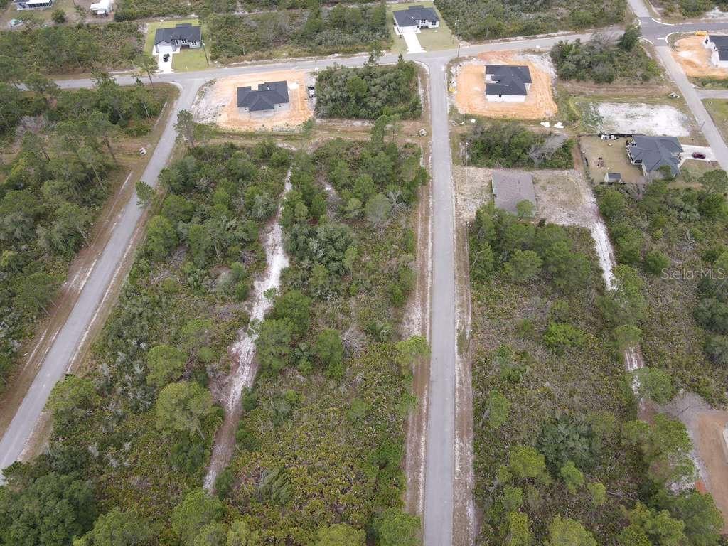 An aerial view shows several houses situated among wooded lots and paved roads — 5044 PUEBLO AVENUE, SEBRING, FL