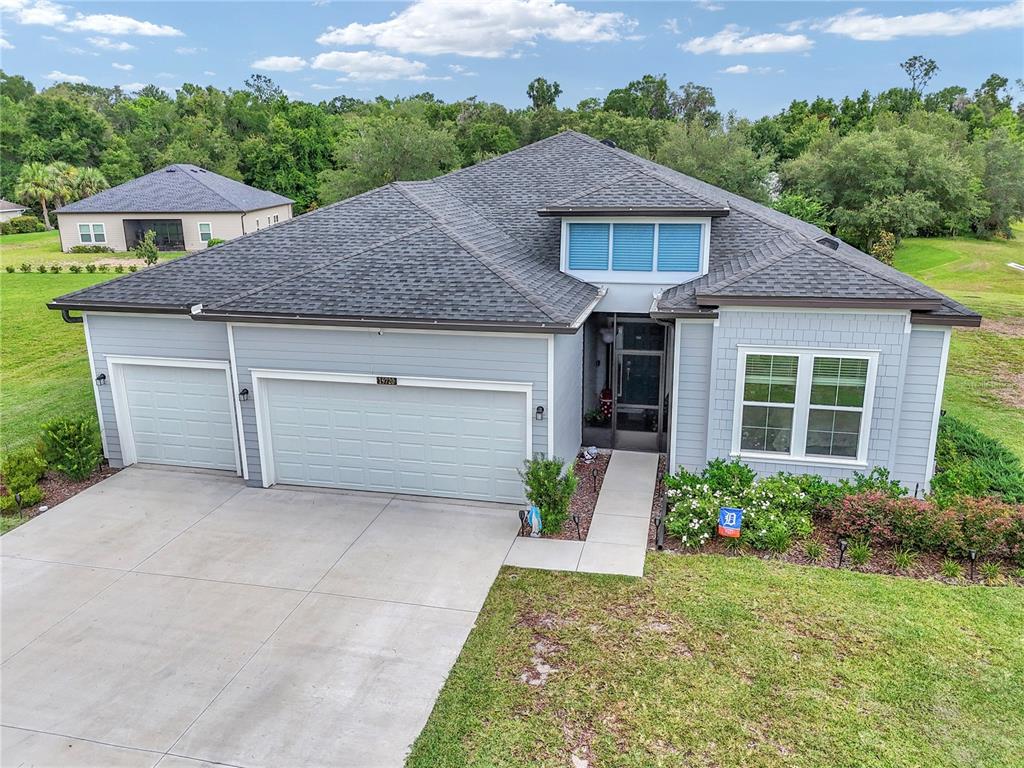 An aerial view of a single-story house with a gray exterior, shingled roof, and garage — 19720 SW 79TH PLACE, DUNNELLON, FL