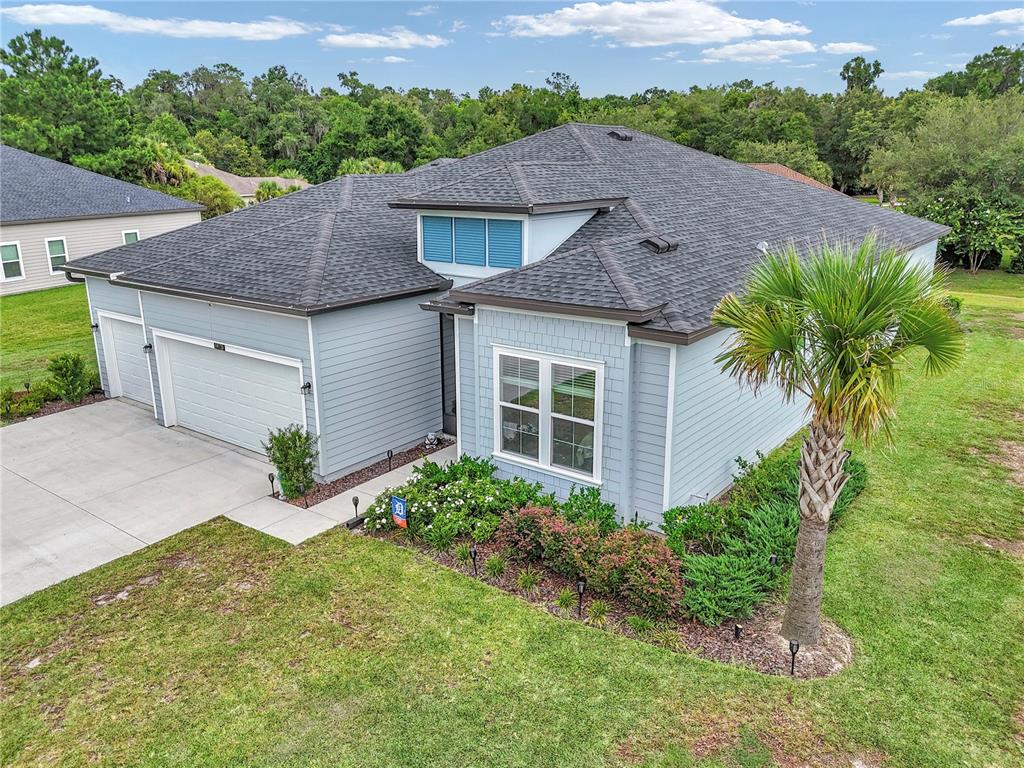 An aerial view of a light blue single-story house with a dark shingled roof — 19720 SW 79TH PLACE, DUNNELLON, FL