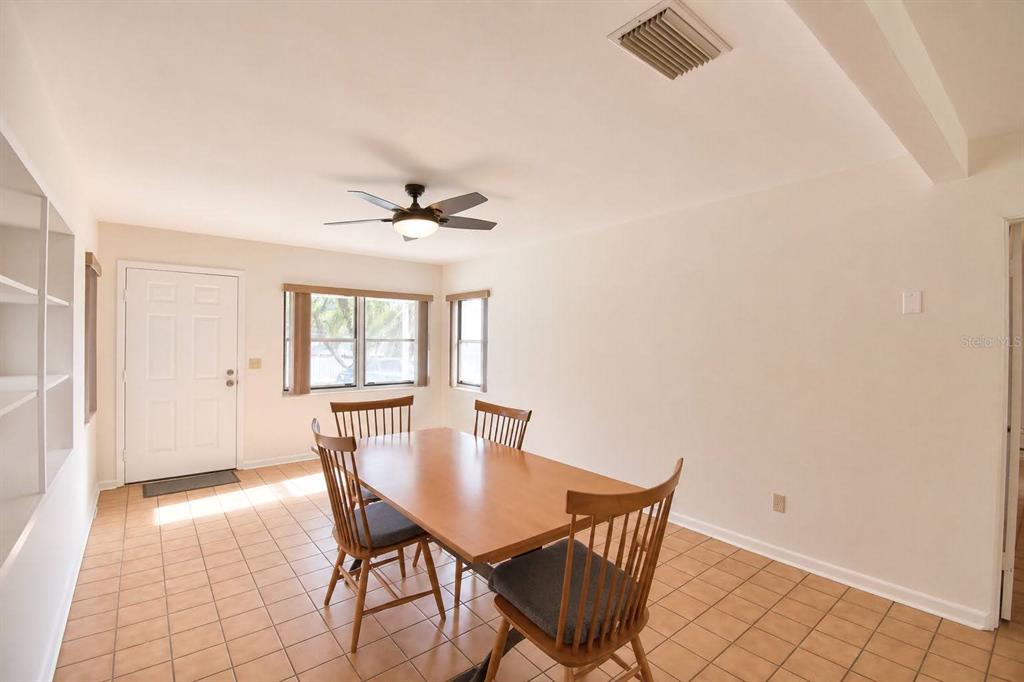 A dining room with tile flooring, a wooden table, four chairs, and a ceiling fan — 906 AVENUE M SE, WINTER HAVEN, FL