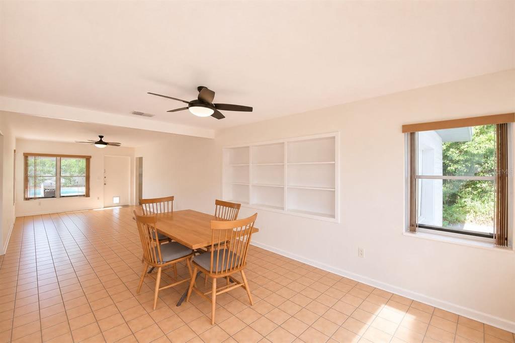 A dining area with tile floors, a wooden table, chairs, and built-in wall shelving — 906 AVENUE M SE, WINTER HAVEN, FL