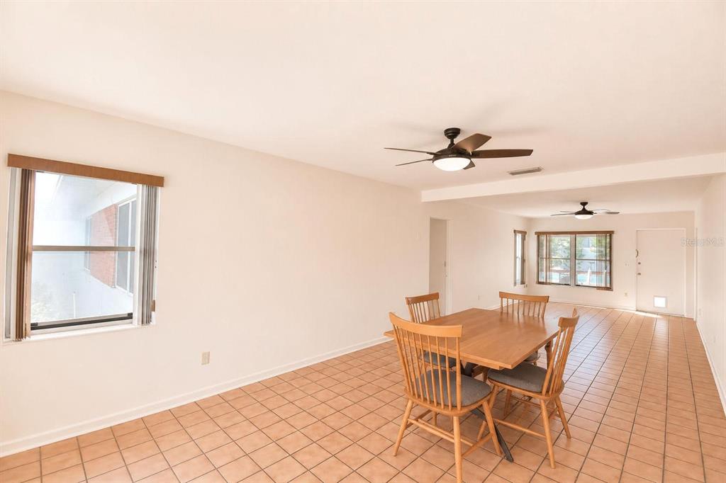 A dining area with tile flooring, a wooden table, and two ceiling fans — 906 AVENUE M SE, WINTER HAVEN, FL