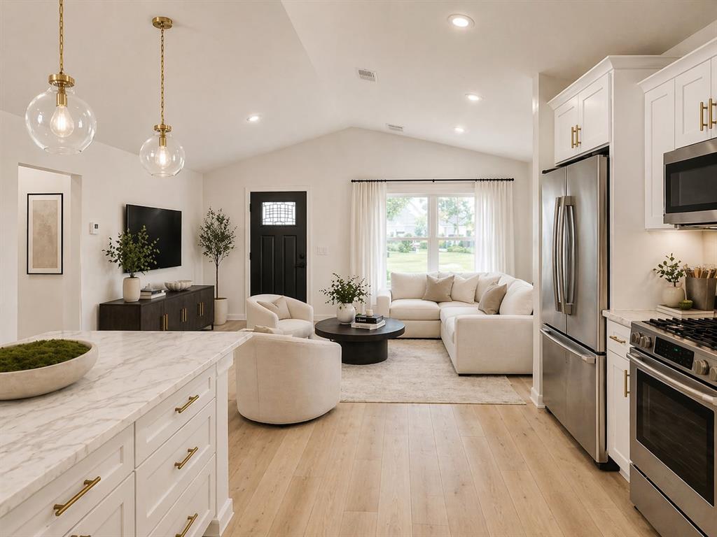 An open-concept kitchen and dining area features a round wooden table, island seating, and cabinetry — 11081 SW 107TH PLACE, DUNNELLON, FL