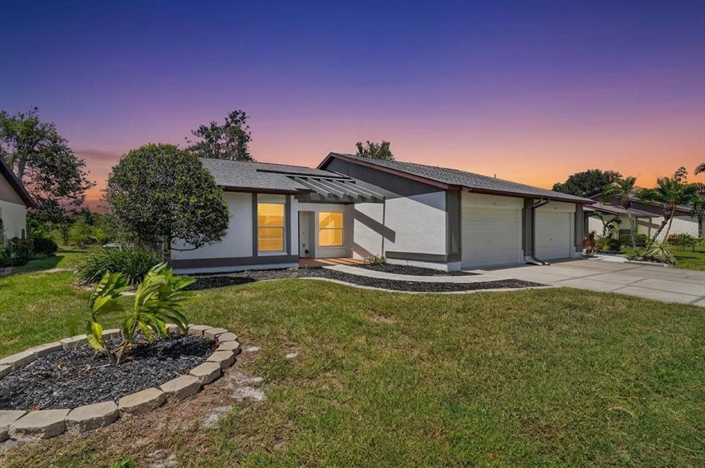 A single-story house with a white exterior, a two-car garage, and a front yard — 631 FOXWOOD BOULEVARD UNIT 256, ENGLEWOOD, FL