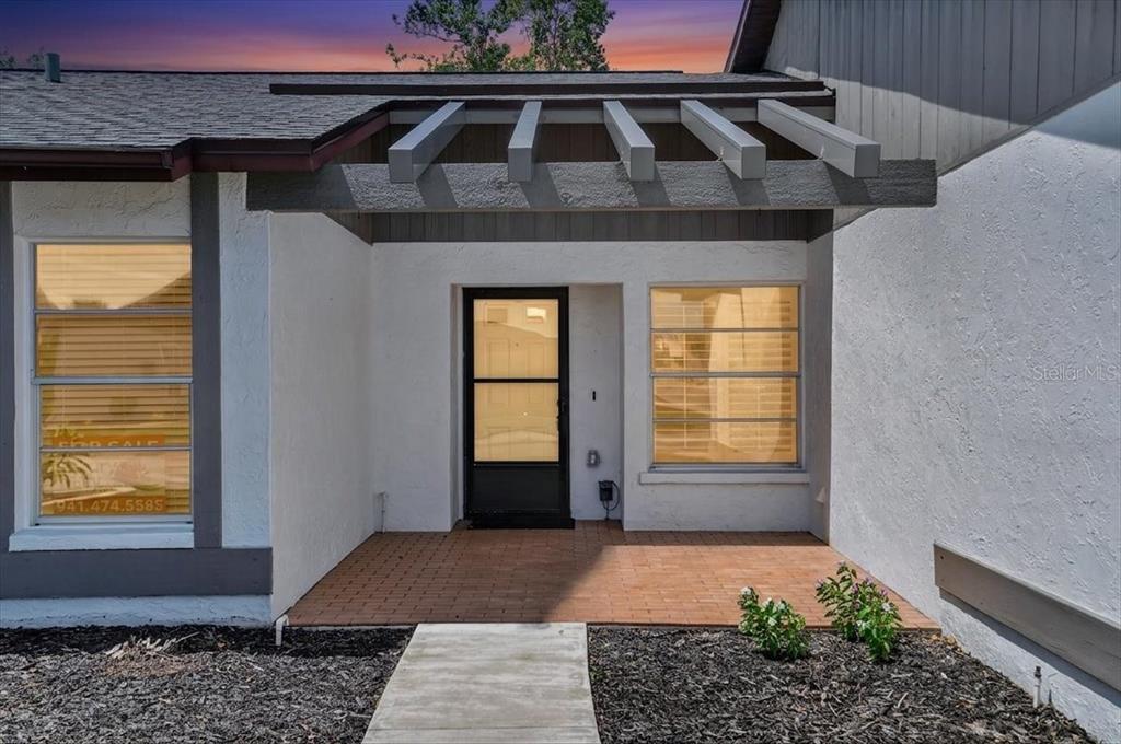 A front entryway features a brick porch, a pergola, and two large windows — 631 FOXWOOD BOULEVARD UNIT 256, ENGLEWOOD, FL