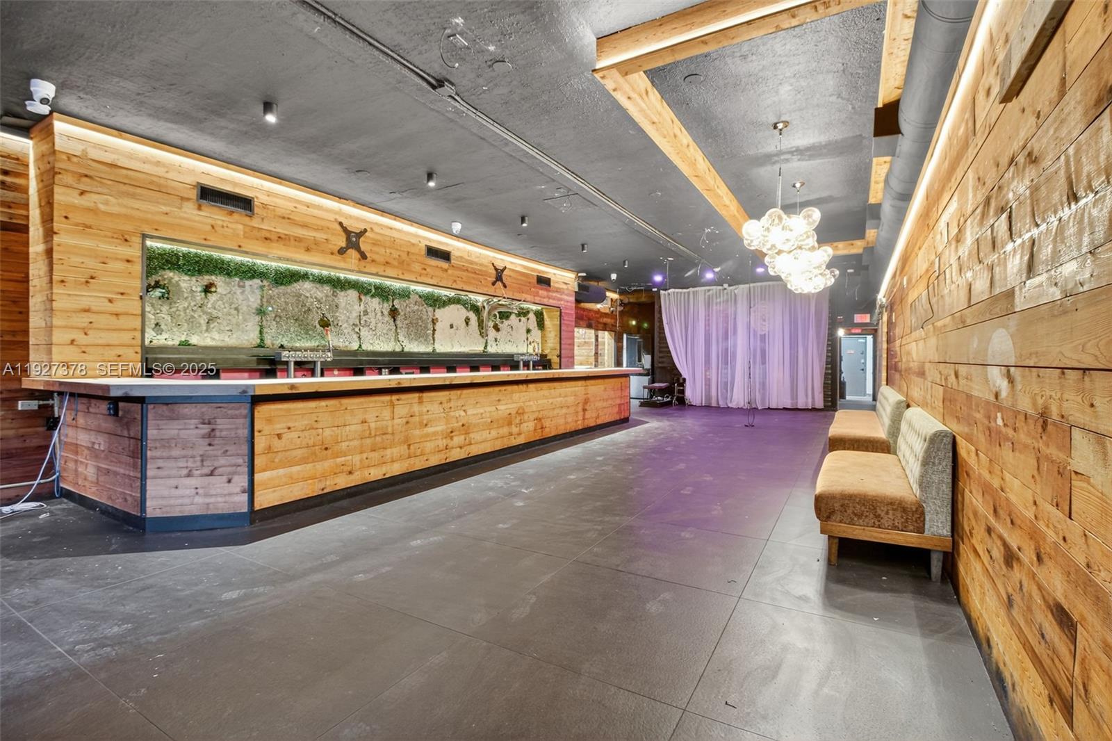 A long bar with wood paneling and a green wall sits in a room with tile floors — 1216 Washington AVE, Miami Beach FL 33139, MIAMI BEACH, FL