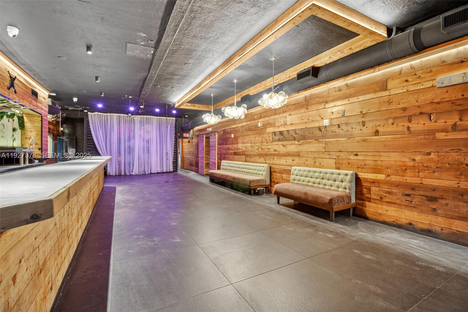 A commercial space features a long bar, wood-paneled walls, tile flooring, and tufted benches — 1216 Washington AVE, Miami Beach FL 33139, MIAMI BEACH, FL