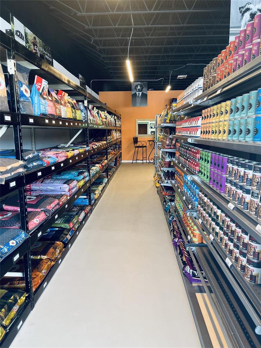 A narrow aisle in a pet supply store features metal shelving stocked with various products — 1135 US Highway 1, Vero Beach FL 32960, VERO BEACH, FL