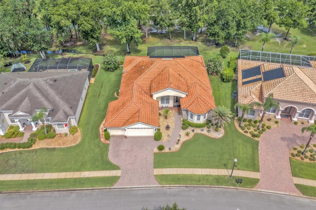 An aerial view shows a single-story house with a terracotta tile roof and screened pool — 5151 DELACROIX DRIVE, BROOKSVILLE, FL