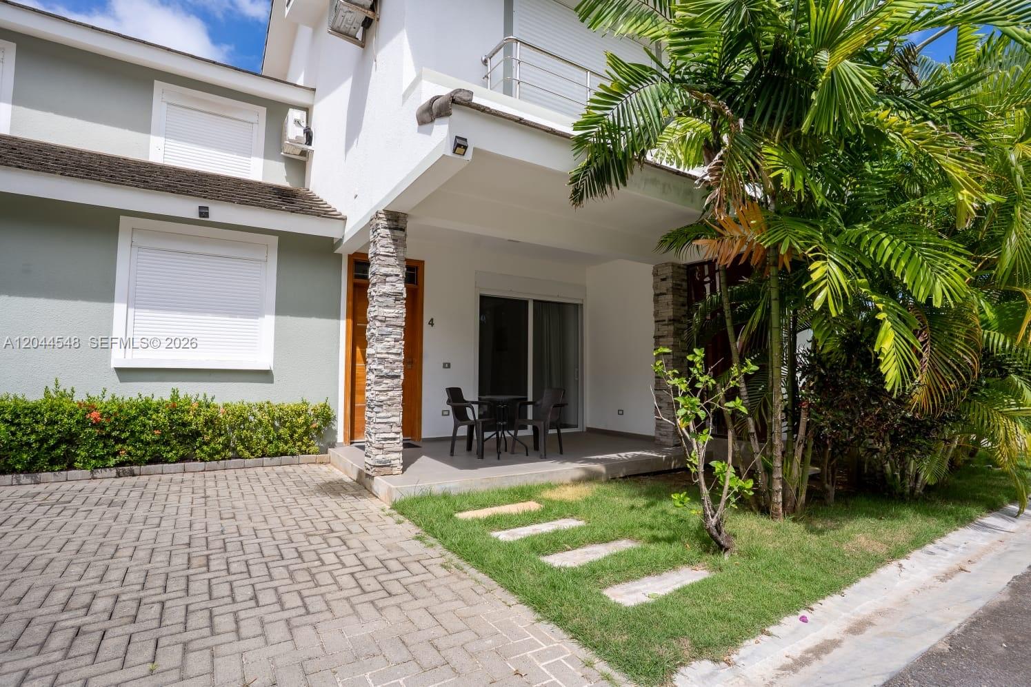 A two-story house exterior features a paved driveway, a covered patio, and a palm tree — 01 Calle Mariano Vanderhorst, FL 32000, FL