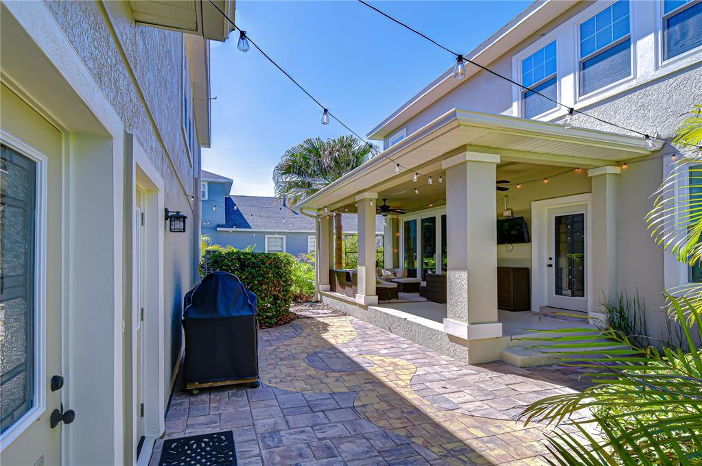 A paved patio area features a covered porch, outdoor lighting, and a grill — 6135 CHURCHSIDE DRIVE, LITHIA, FL