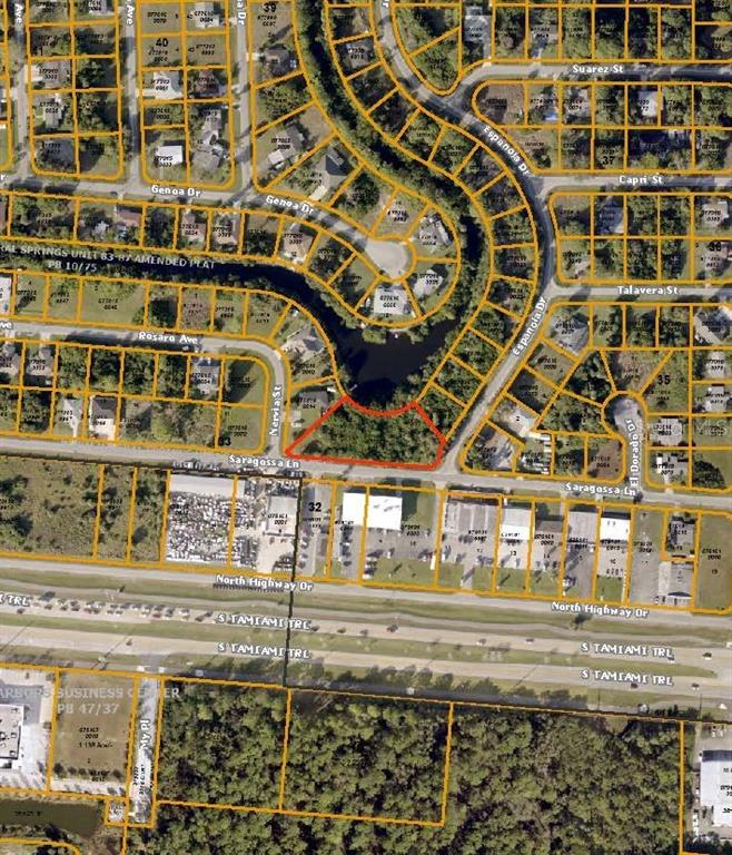 This is an aerial map showing a vacant, wooded lot highlighted in red near a canal — LOTS 15,16,17 SARAGOSSA LANE, NORTH PORT, FL