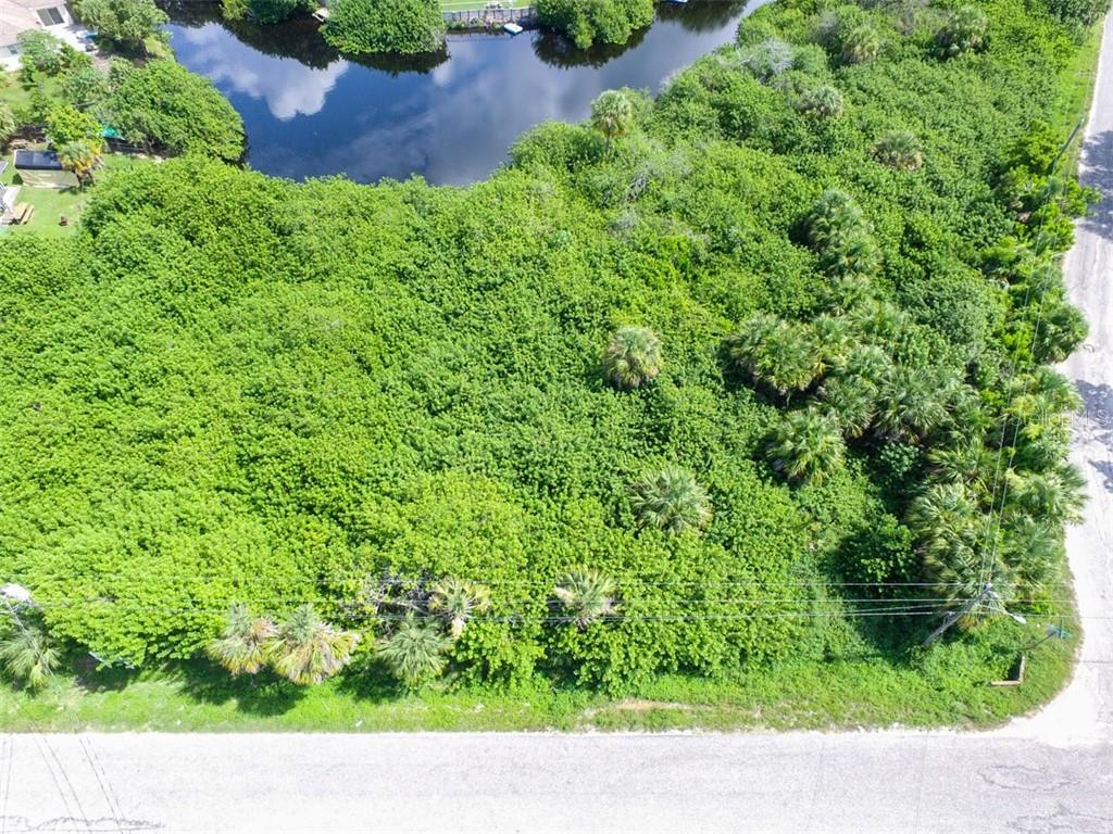 An aerial view of a densely wooded, undeveloped rectangular lot bordering a small pond — LOTS 15,16,17 SARAGOSSA LANE, NORTH PORT, FL