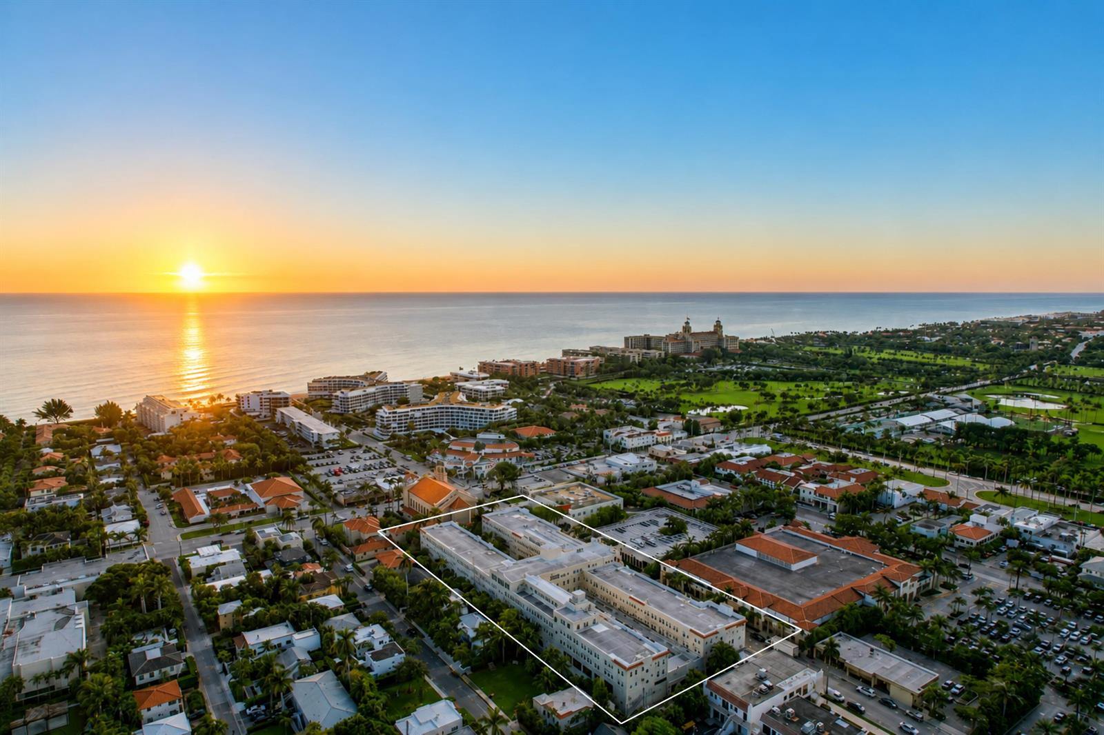 An aerial view shows a large, multi-story building highlighted by a white outline at sunset — 235 Sunrise # 3244, Palm Beach FL 33480, PALM BEACH, FL