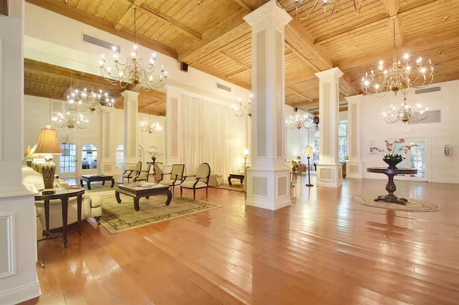 A spacious lobby features hardwood floors, a wood-paneled ceiling, large white columns, and crystal chandeliers — 235 Sunrise # 3244, Palm Beach FL 33480, PALM BEACH, FL