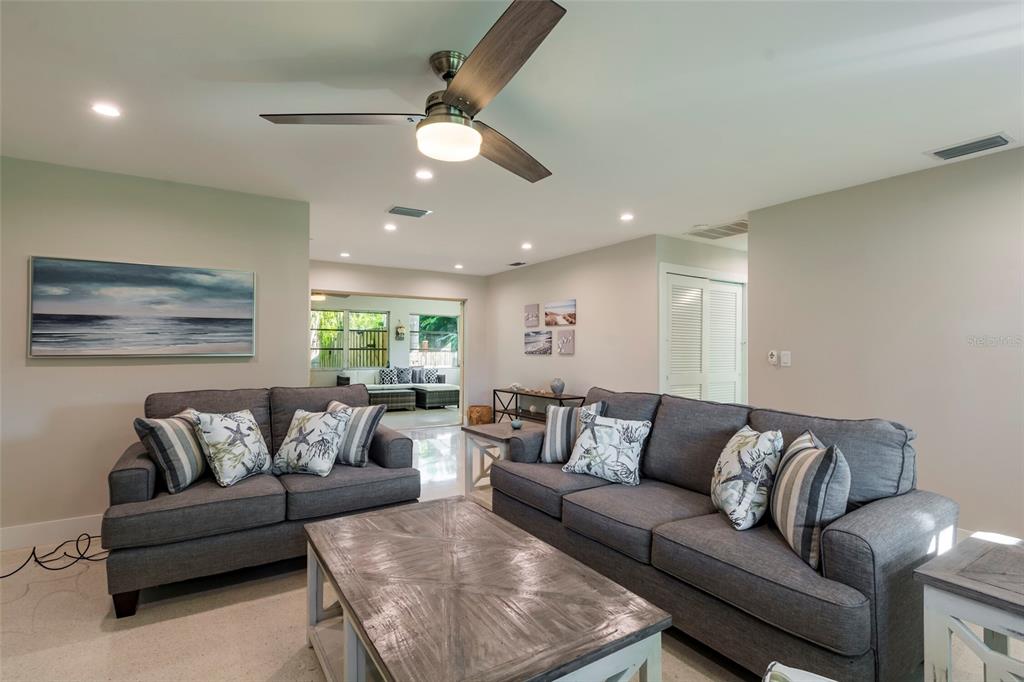 A living room features two gray sofas, a wooden coffee table, and a ceiling fan — 3005 CHASE CIRCLE, SARASOTA, FL
