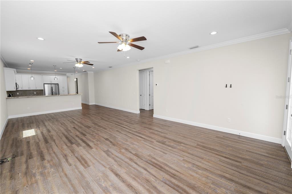 An open-concept living area features wood-look flooring, recessed lighting, ceiling fans, and a kitchen island — 3725 57TH AVENUE N, ST PETERSBURG, FL