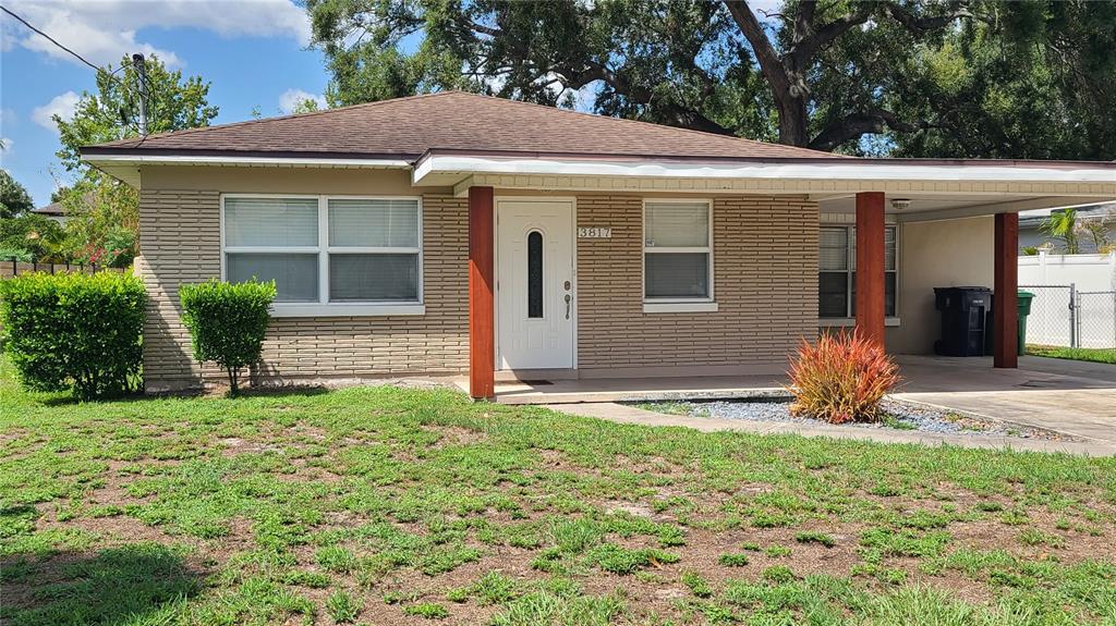 A single-story brick house features a front porch, a carport, and a small front yard — 3817 W SAN RAFAEL STREET, TAMPA, FL